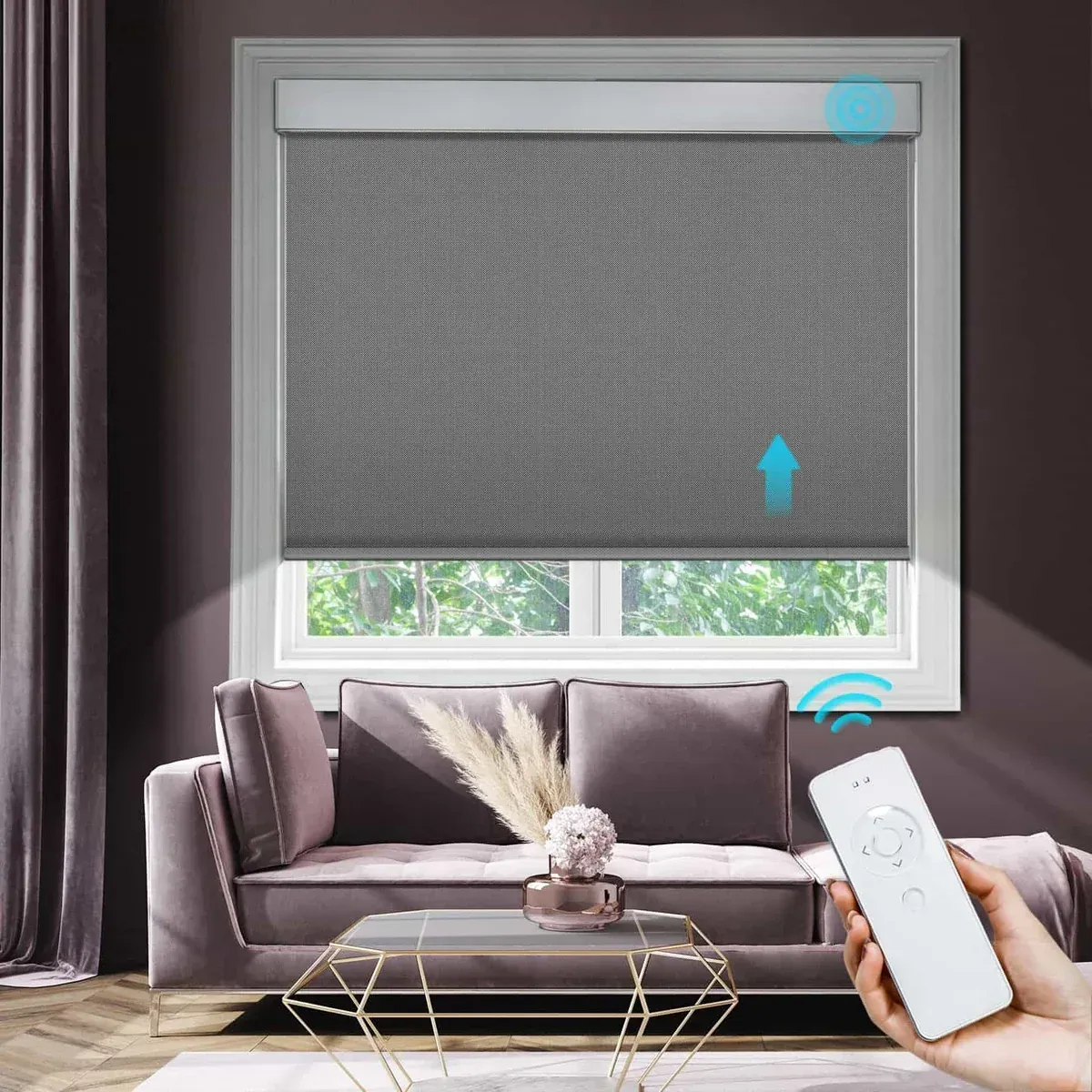 Grey motorized roller shade over a living room window with a handheld remote