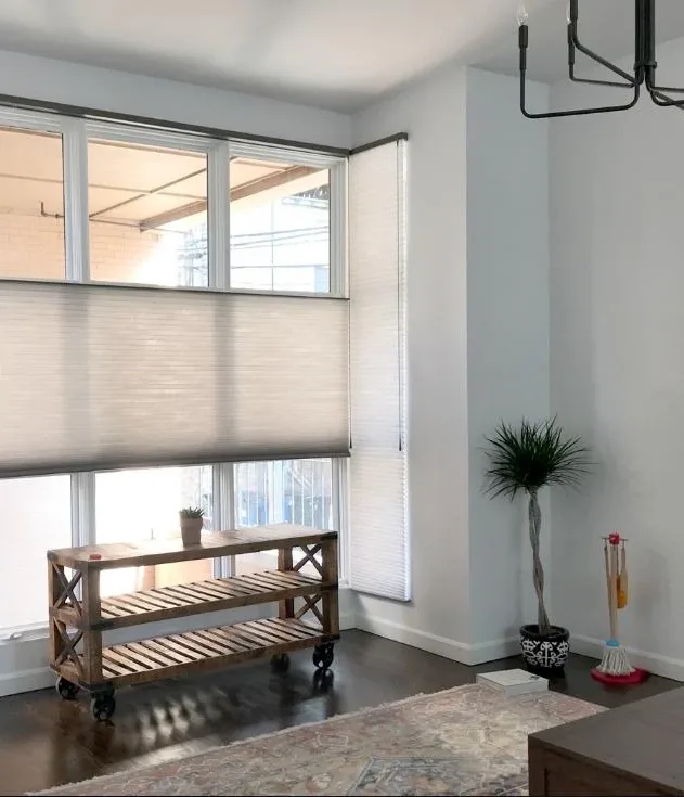 Top-down bottom-up cellular shade set mid-window on a tall window beside a console table
