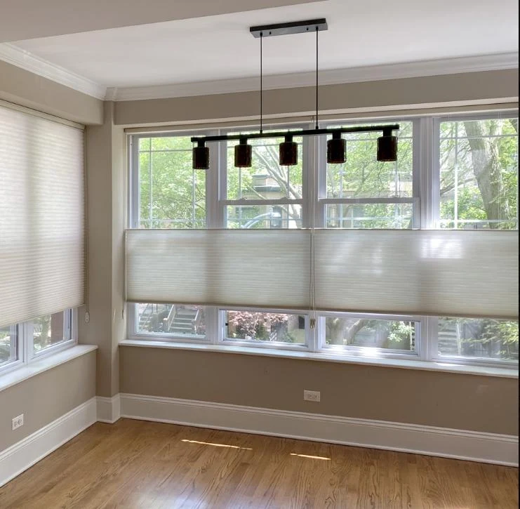 Top-down bottom-up cellular shades on three windows of a dining nook