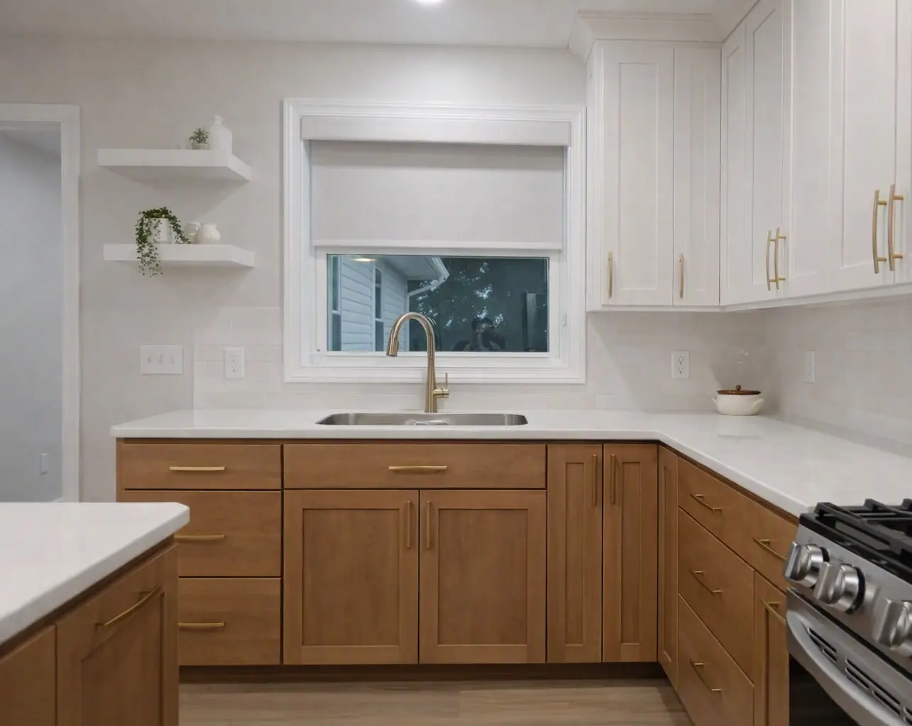 White roller shade with a matching valance over a kitchen sink window between white and oak cabinets